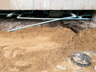 The installation of a septic tank near a building under construction.