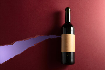 Bottle of red wine with old empty label on a dark red background. - 788607309