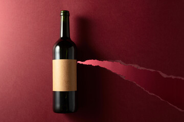 Bottle of red wine with old empty label on a dark red background. - 788607320