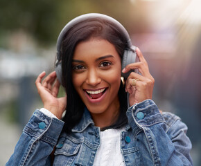 Headphones, portrait or happy Indian woman in city or town for streaming a song, music or radio....