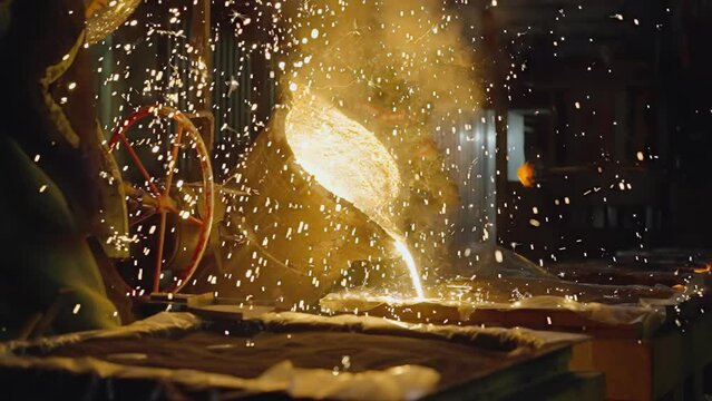 Intense glow and fierce sparks as foundry workers in protective gear courageously pour searing molten meta