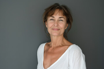 Fototapeta premium A woman in a white shirt smiles for the camera