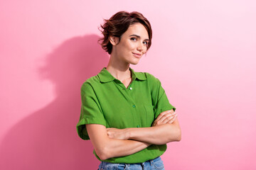 Photo of cheerful positive young woman dressed green shirt smiling arms crossed isolated pink color...