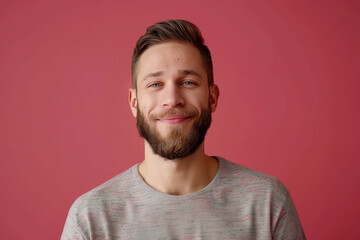 Fototapeta premium A man with a beard is smiling in front of a pink background