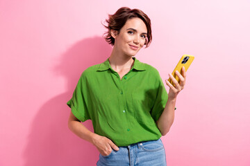 Photo of good mood pretty young woman dressed green shirt chatting instagram twitter telegram facebook isolated pink color background