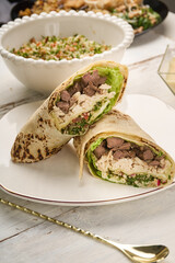 Shawarma chicken roll in a pita with fresh vegetables, cream sauce and Arabic Cuisine: Middle Eastern traditional lunch. It's also Ramadan 
