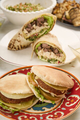 Shawarma chicken roll in a pita with fresh vegetables, cream sauce and Arabic Cuisine: Middle Eastern traditional lunch. It's also Ramadan 