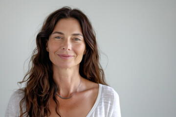 Fototapeta premium A woman wearing a white shirt and a necklace smiles for the camera