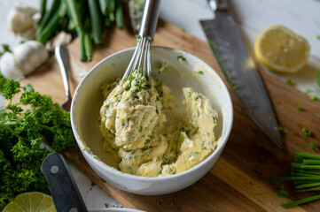Fresh prepared herb butter on a wooden cutting board.