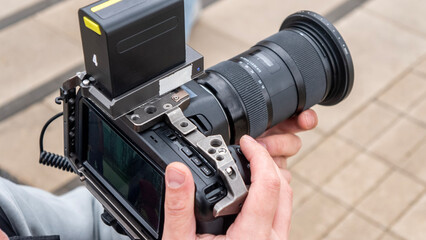 professional camera with expensive optics in the hands of the operator during video shooting