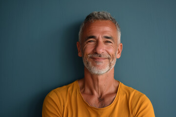 Obraz premium A man with gray hair and a yellow shirt smiles for the camera