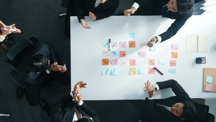 Top down aerial view of business group sharing and brainstorming idea by using sticky notes at...