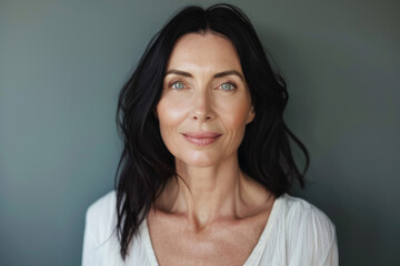 A woman with dark hair and green eyes smiles for the camera