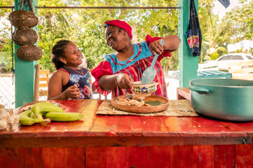 African American mother and daughter or grandmother and granddaughter enjoy the moment of being together in the kitchen. Happy family in the kitchen.