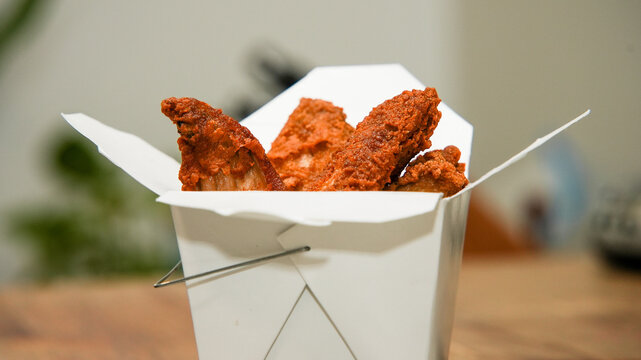 Crispy Fried Chicken Strips in a Takeout Box on a Kitchen Counter