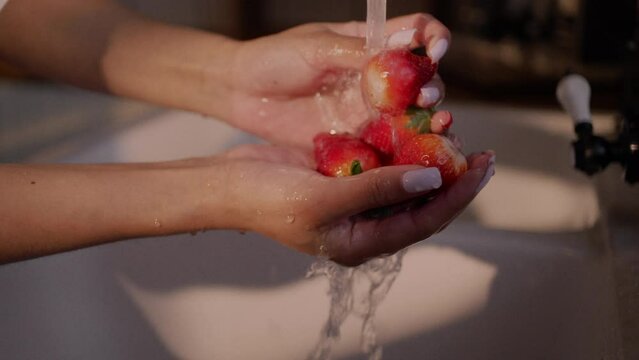 Eating strawberries, washing and preparing vegetables in the kitchen