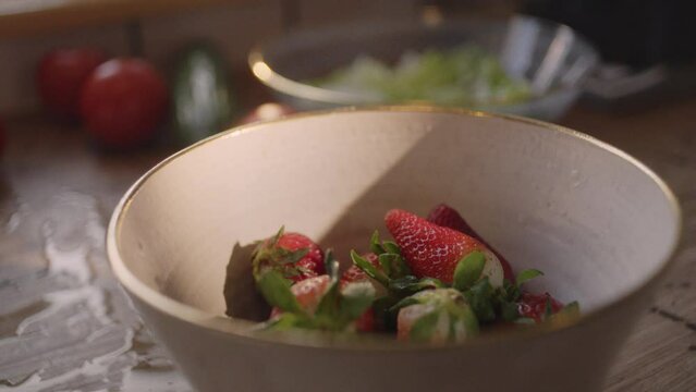 Eating strawberries, washing and preparing vegetables in the kitchen