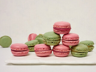 Raspberry and pistachio macarons on a white background