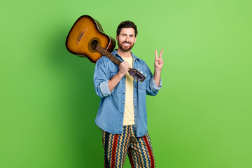 Photo of good mood handsome guy wear denim jacket showing v-sign playing guitar empty space...