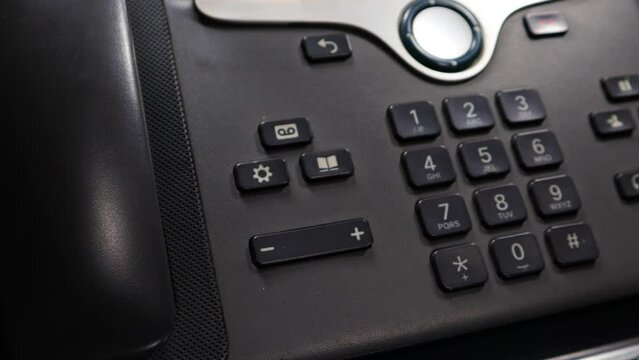 A low-angle clip of a used IP phone placed on a glass sheet with the reflection of the phone, rotating on an automatic display stand.