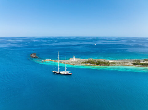 Aerial view of transparent turquoise waters surrounding Nassau Harbour Lighthouse, Paradise Island, The Bahamas.