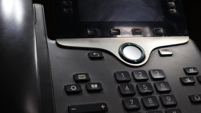 A closeup and cinematic clip of a used IP phone placed on an automatic display stand.