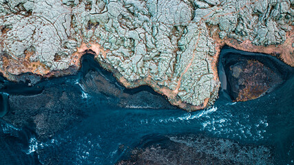 Aerial drone top-down view of Eldrhaun Lava Fields overgrown with moss and blue river, South Iceland.