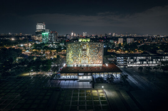 Aerial drone view of Biblioteca Central UNAM, a famous library in Ciudad Universitaria in Mexico City at night, Mexico.