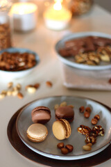 Cup of tea or coffee, cookies, macaroons, chocolate, various nuts and cocoa powder on white background. Selective focus.