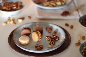 Cup of tea or coffee, cookies, macaroons, chocolate, various nuts and cocoa powder on white background. Selective focus.
