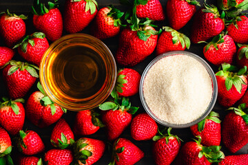 Strawberry Bourbon Preserve Ingredients: Fresh strawberries surrounding dishes of bourbon whiskey and organic cane sugar viewed from directly above