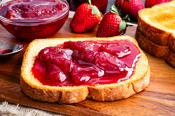 Slice of Toast Covered in Homemade Strawberry Preserves: Sliced and toasted white bread and homemade strawberry preserves with large slices of fruit