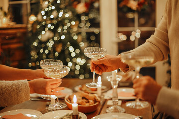 Happy friends clinking champagne glasses while celebrating New Years Eve or Christmas