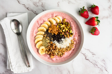 Strawberry Smoothie Bowl Loaded with Healthy Toppings: Fruit smoothy bowl with sliced banana,...