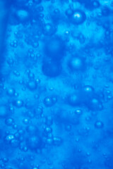 Bubbles in blue water macro close up abstract background.