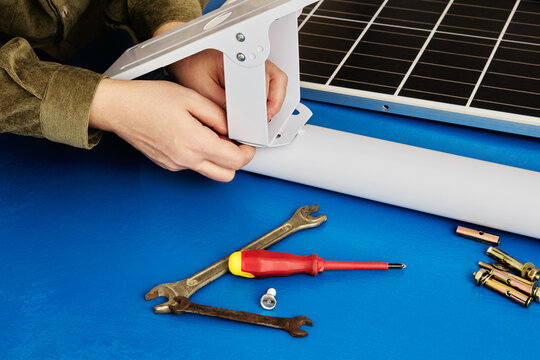 Homeowner assembles solar panel holder to use green technology on his property.
