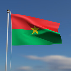Burkina Faso Flag is waving in front of a blue sky with blurred clouds in the background