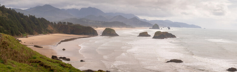 Naklejka premium View of Haystack Rock from Ecola State Park. Known for some of the best views on the Oregon Coast and Haystack Rock, Ecola State Park is an ideal spot to watch enormous storm waves roll in.