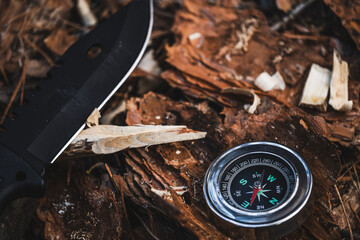 Compass and knife on the wood. Adventure and travel concept.