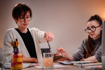 Two designers in deep discussion, one gesturing to express her point, capturing a moment of...