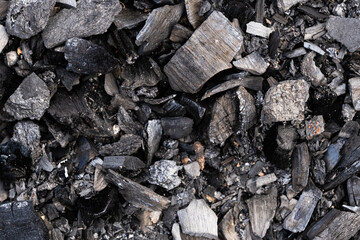 Background is made black coal. Texture of black charcoal in closeup. Black coal from an extinct campfire.