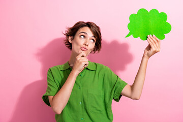 Photo portrait of attractive woman hold paper cloud look thoughtful wear trendy green clothes isolated on pink color background