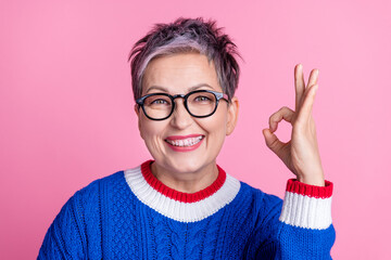 Photo of nice aged lady show okey symbol wear blue sweater isolated on pink color background
