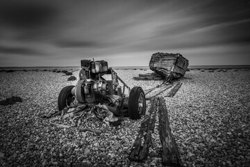 Abandoned and damaged wooden fishing boat connected to a tug on English beach, Image shows a old...