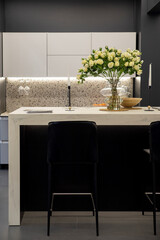 Modern designer kitchen with black chairs and a granite island