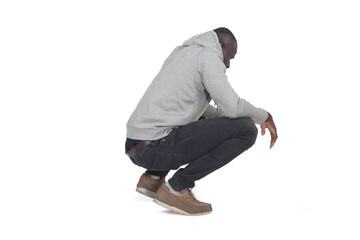 side view of man squatting and looking down on white background - 788736954