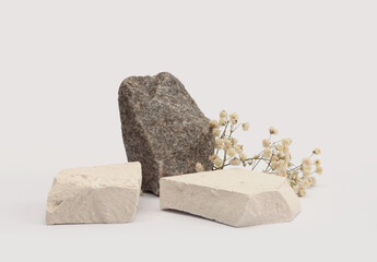 White, gray Stones platform podium, dry flower twig on beige light background. Minimal empty display product presentation scene.