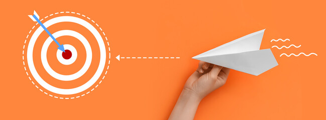 Woman with white paper plane on orange background