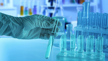 Scientist holding test tube with liquid in laboratory