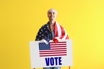 Young man with USA flag and blank poster on yellow background